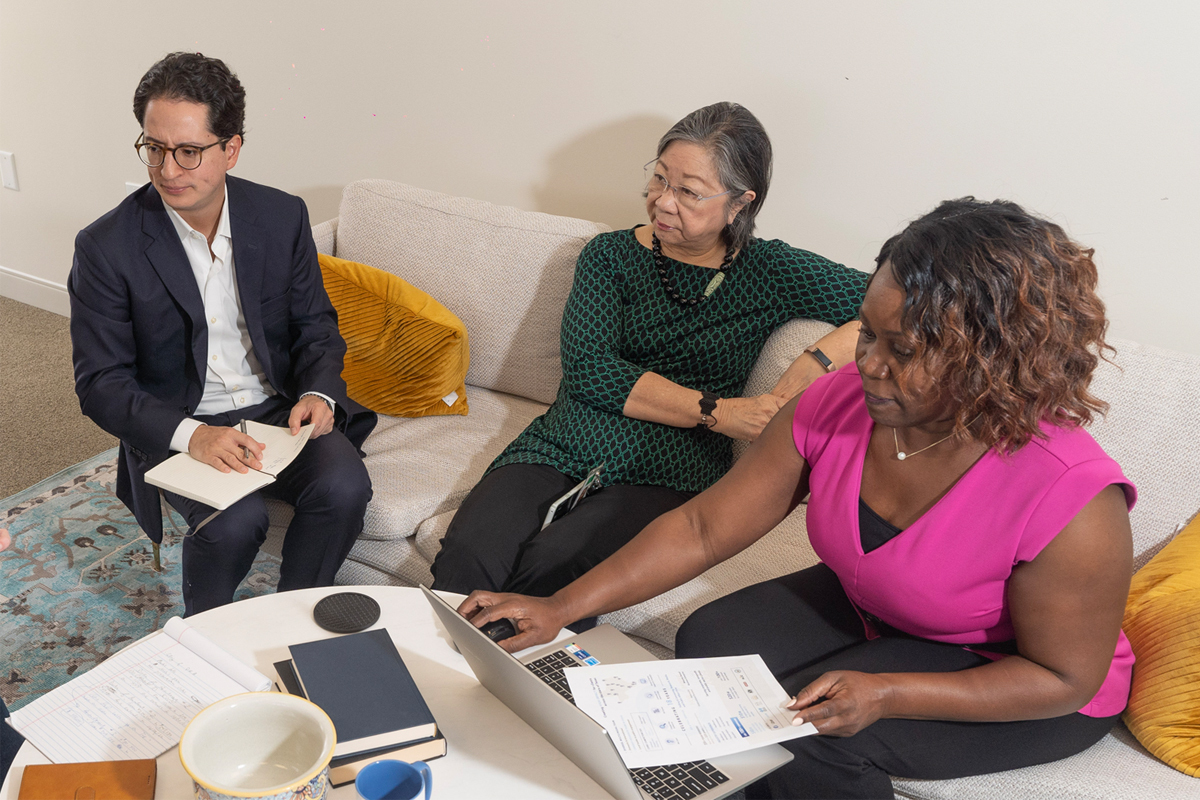 Image of 3 Outreach Strategists employees, a man and 2 women, working together in a diverse and multicultural environment.